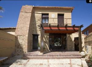 a large brick house with a porch and a balcony at Rincón de San Cayetano in Villalpando