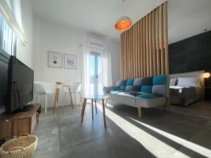 a living room with a blue couch and a television at Marton Perissa in Perissa