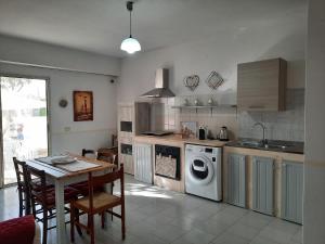 een keuken met een tafel en een wasmachine bij Casa Samuel in Galtellì