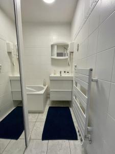 a white bathroom with a sink and a mirror at Residence Louis Quartier Centre Ville in Vittel