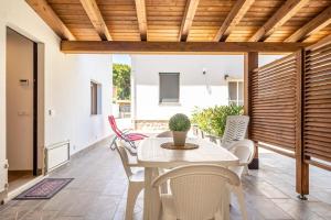 a dining room with a white table and chairs at Le Casette Di Maria Pia in Mondello