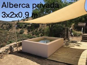 a large umbrella sitting on top of a wooden deck at Casa del Ingeniero 4 Hab 8 Pers 3 Chimeneas con horno in Puerto de la Laja