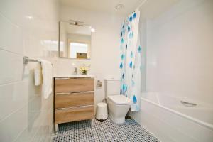 ein Badezimmer mit einem WC, einem Waschbecken und einem Spiegel in der Unterkunft Apartamentos Rincón del Mar in Torre del Mar
