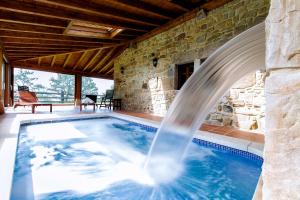 una piscina con una fuente de agua en una casa en Casas Rurales La Cuplia, en Pedroso