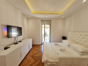 1 dormitorio blanco con 1 cama grande y TV de pantalla plana en Apartment Lido 50m From The Beach, en Opatija