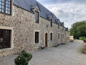a large stone building with a pathway in front of it at Le Château de Quinéville in Quinéville