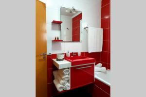 a red bathroom with a sink and a mirror at Hill & Sea House in Ribeira Grande +30 photos