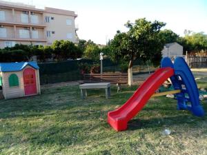 a playground with a red slide and a bench at Mamanis Studios in Loutra Edipsou