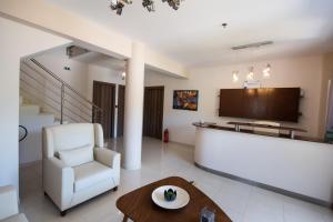 a living room with a white chair and a table at Aurora Studios in Nikiana