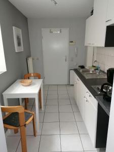 a small white kitchen with a table and a sink at Ferienwohnung Dillamar in Veitshöchheim