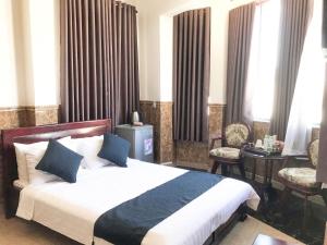 um quarto com uma cama, uma mesa e cadeiras em La Cactus Hotel 2 em Quy Nhon