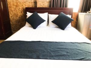 a large bed with two pillows on top of it at La Cactus Hotel 2 in Quy Nhon