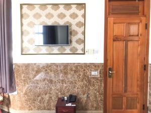 a television on a wall next to a door at La Cactus Hotel 2 in Quy Nhon