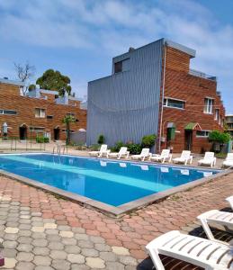 a swimming pool with lounge chairs and a building at Seaside cottages in Chakvi
