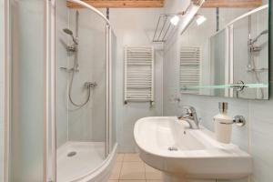 a white bathroom with a sink and a shower at Mini Hotel Laplandiya in Bukovel