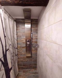 a bathroom with a walk in shower with a wall at Agora Boutique Apartments Ioannina in Ioannina