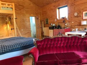 a red couch in a room with a kitchen at Assen-Groningen-Saunacabine in Vries