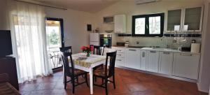 a kitchen with a table and chairs and a kitchen with white cabinets at NORA home in Novigrad Istria