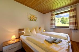 a bedroom with a bed with two pillows and a window at Bauernhof Klausbauer in Grossarl