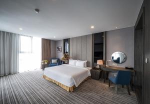Postel nebo postele na pokoji v ubytování Muong Thanh Luxury Saigon Hotel