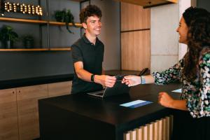 a man and woman shaking hands at a table with a laptop at CAB20 in Hamburg