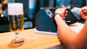 a person holding a cell phone next to a glass of beer at CAB20 in Hamburg