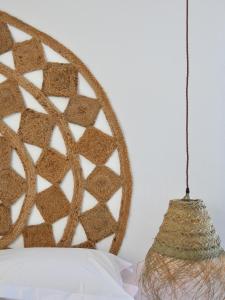 a hanging rattan pendant light next to a wall at Harbour View House in St Ives