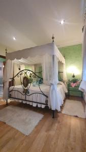 a bedroom with a bed with a canopy at Viviendas Turísticas El Carrascal in La Gandara