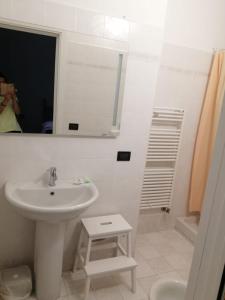 a white bathroom with a sink and a mirror at Casa Vincenzo in Bologna