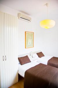 two beds in a room with white walls at Claris Apartments in Barcelona