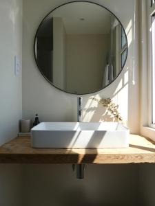 a bathroom with a white sink and a mirror at Harbour View House in St Ives