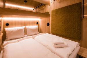 Schlafzimmer mit einem Bett mit weißer Bettwäsche und Kissen in der Unterkunft CAB20 in Hamburg