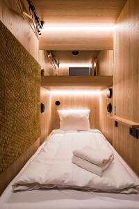 Bett in einem kleinen Zimmer mit Licht in der Unterkunft CAB20 in Hamburg
