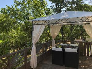 a canopy on a deck with a table and chairs at Camping de Parpaillon in Roquebrune-sur-Argens