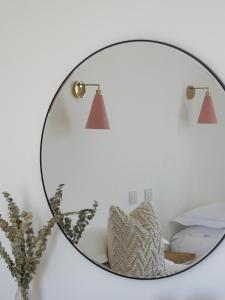 a mirror on a wall next to a bed at Harbour View House in St Ives
