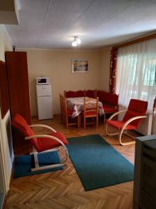 uma sala de estar com mesa e cadeiras em Twins House - Janka Apartman em Bogács