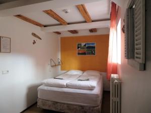 a small bedroom with a bed and a window at Húsavík Green Hostel in Húsavík