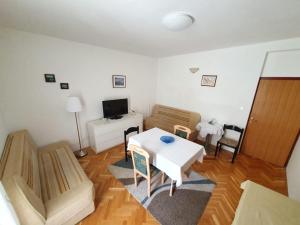 Apartmani Ivanka في فوديس: غرفة معيشة مع طاولة وكراسي بيضاء