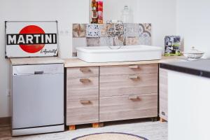 a kitchen with a sink and a dishwasher at Appartement ForRest - balcon privé et piscine, près de Lyon in Lay