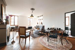 a kitchen and living room with a table and chairs at Appartement ForRest - balcon privé et piscine, près de Lyon in Lay