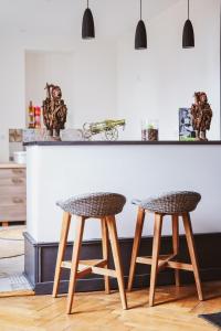 a kitchen with a counter with two stools at Appartement ForRest - balcon privé et piscine, près de Lyon in Lay