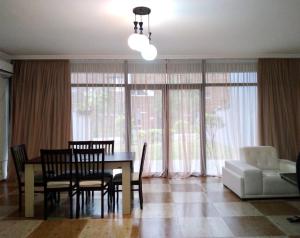 a dining room with a table and chairs and a couch at Seaside cottages in Chakvi