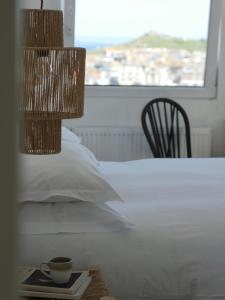 a bedroom with a bed and a cup of coffee on a table at Harbour View House in St Ives