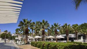 a resort with palm trees and tables and umbrellas at Apartamento Amplio junto al Centro in Málaga