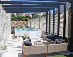 un patio con muebles de mimbre y una piscina en Apartments Skandi1, en Malinska
