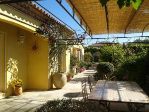 a patio with a table and chairs in a garden at Aux Amandiers in Fréjus