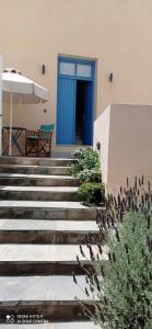 a blue door on a building with stairs and a bench at Chora View in Kythira