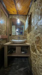 a stone bathroom with a sink and a mirror at Старата баkалия The old grocery, guest rooms in Balchik
