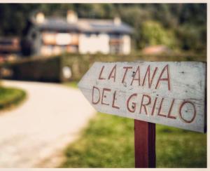 una señal frente a una casa con un patio en LA TANA DEL GRILLO, en Feltre