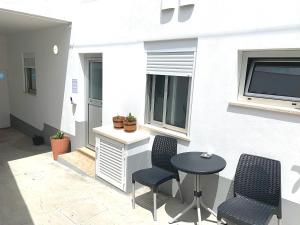 a patio with two chairs and a table and a window at Duarte Houses - Casa T1 N - com vista mar in Nazaré